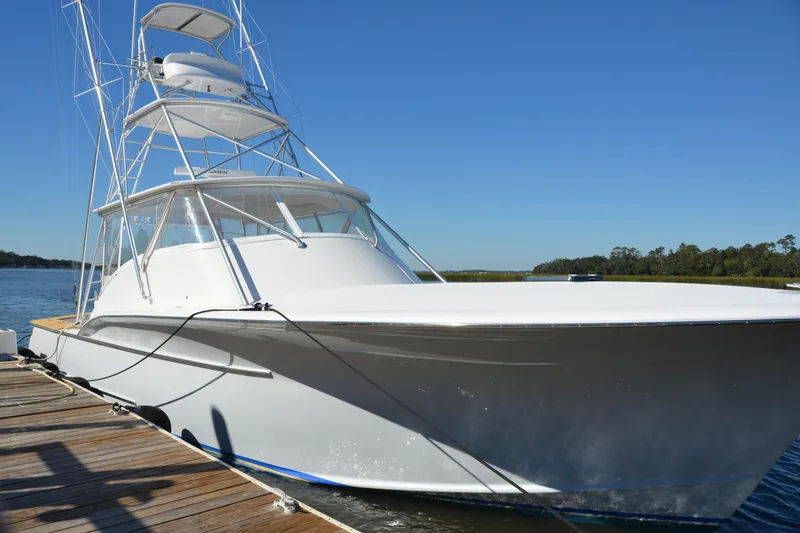 Slide: The Image of 2006 Custom Carolina Heritage Express boat docked on a sunny day. - 24