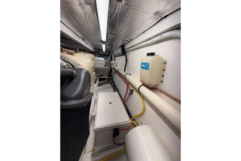 Slide: The Image of Engine room of 2006 Custom Carolina Heritage Express boat, featuring pipes and equipment. - 33