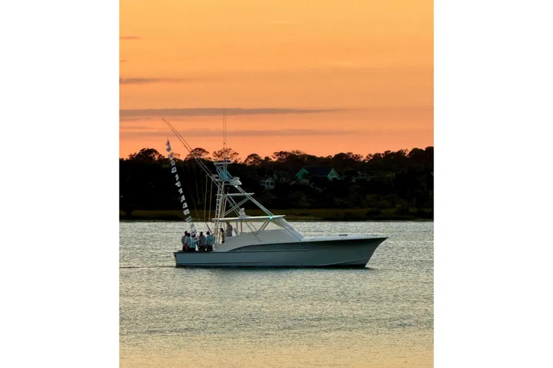 Slide: The Image of 2006 Custom Carolina Heritage Express boat at sunset on calm water. - 39
