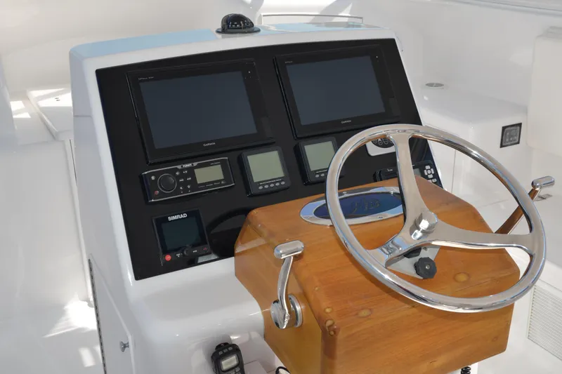 Slide: The Image of Helm of 2006 Custom Carolina Heritage Express boat with navigation screens and wooden steering wheel. - 4