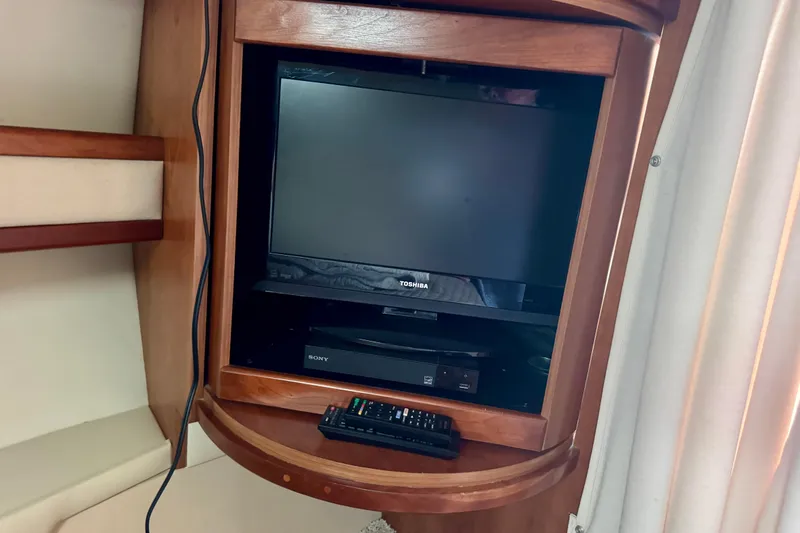 Slide: The Image of Entertainment setup in 2001 Cruisers Yachts 3470 Express cabin with TV and remote. - 12