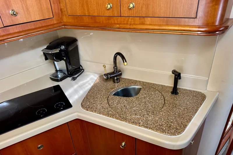 Slide: The Image of 2001 Cruisers Yachts 3470 Express kitchen with sink, stovetop, and coffee maker. - 19