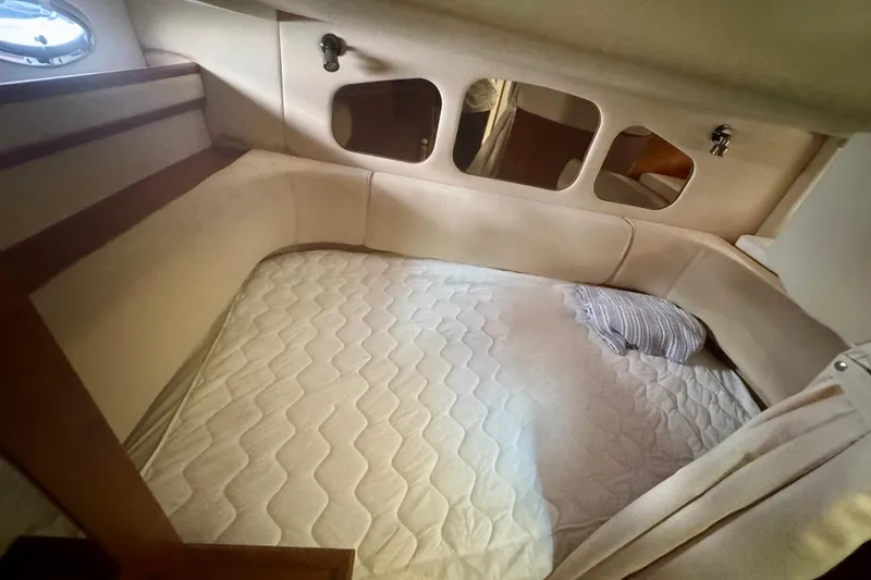 Slide: The Image of 2001 Cruisers Yachts 3470 Express cabin with cozy bed and porthole windows. - 22