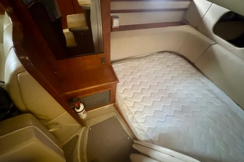 Slide: The Image of 2001 Cruisers Yachts 3470 Express cabin interior with bed and wooden accents. - 23