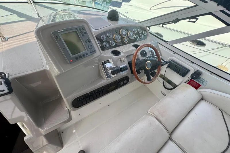 Slide: The Image of 2001 Cruisers Yachts 3470 Express helm with navigation controls and steering wheel. - 24