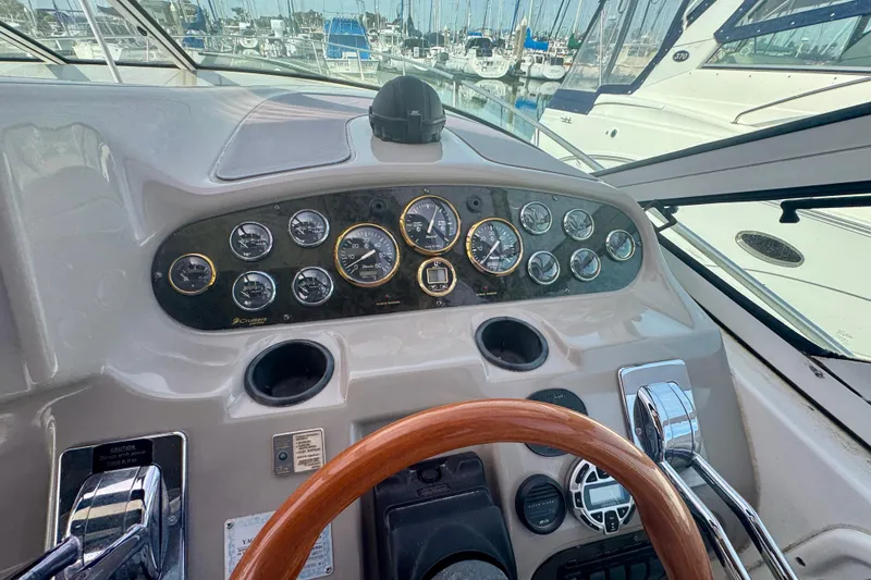 Slide: The Image of 2001 Cruisers Yachts 3470 Express helm with gauges and wooden steering wheel. - 25