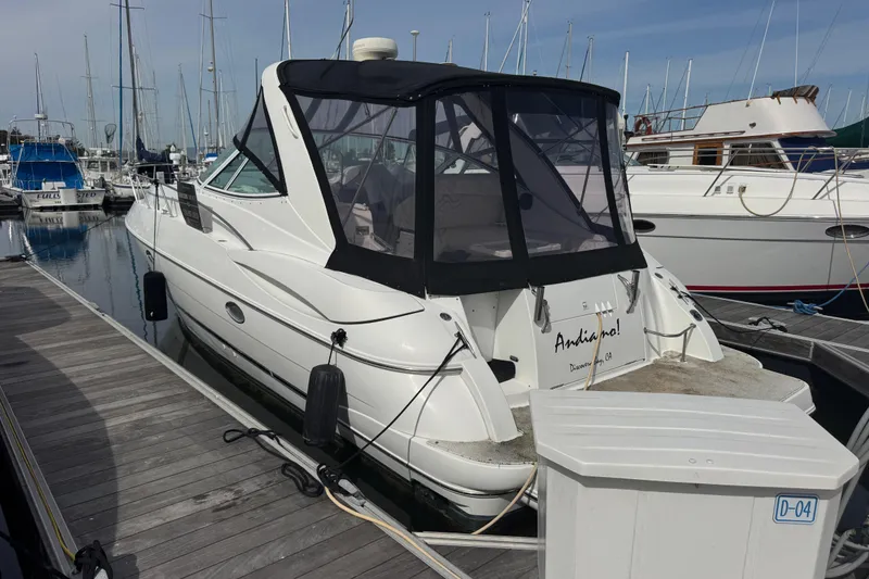 Slide: The Image of 2001 Cruisers Yachts 3470 Express docked at marina, rear view with canopy. - 3