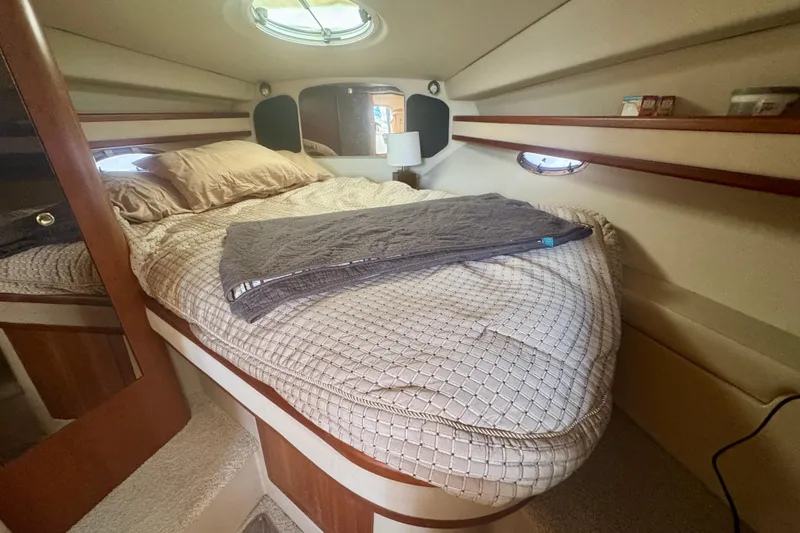 Slide: The Image of Cozy cabin interior of 2001 Cruisers Yachts 3470 Express with bed and porthole. - 8