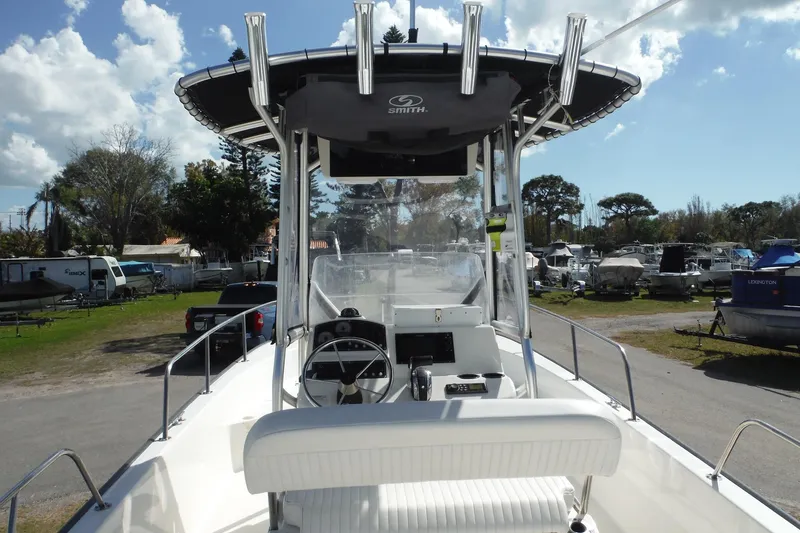 Slide: The Image of 2015 Boston Whaler 210 Montauk boat with center console and T-top in a marina setting. - 11