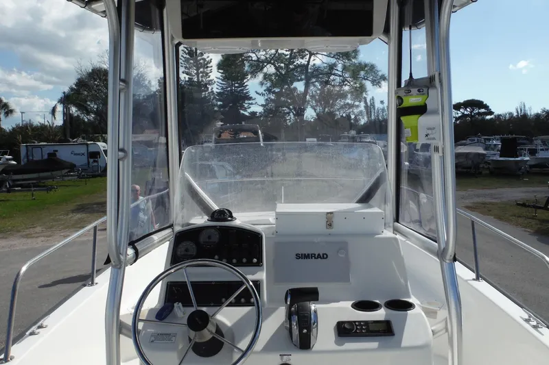 Slide: The Image of 2015 Boston Whaler 210 Montauk boat cockpit with steering wheel and Simrad navigation system. - 39