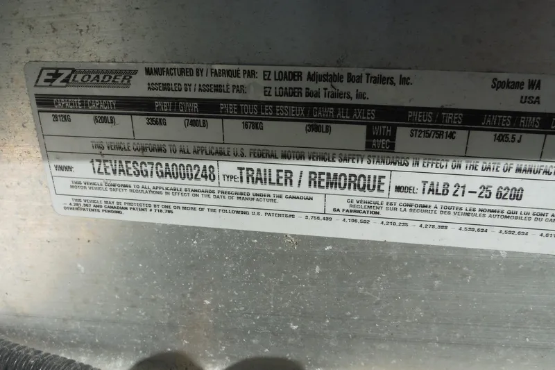 Slide: The Image of Label on EZ Loader trailer, model TALB 21-25 6200, showing specifications and VIN. - 48