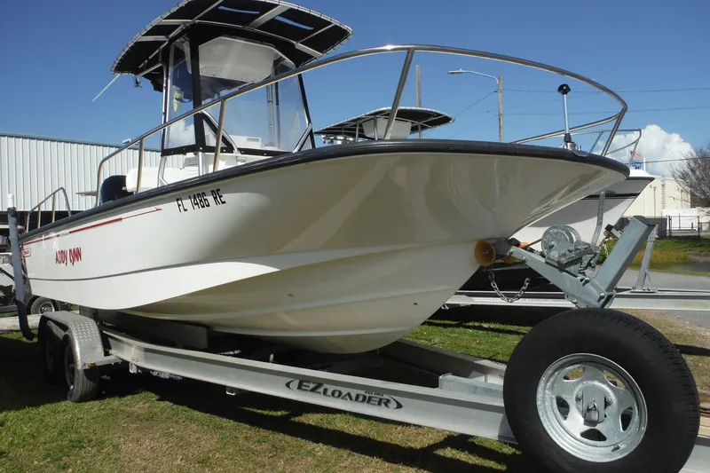 Slide: The Image of 2015 Boston Whaler 210 Montauk boat on trailer, displayed outdoors under clear sky. - 49