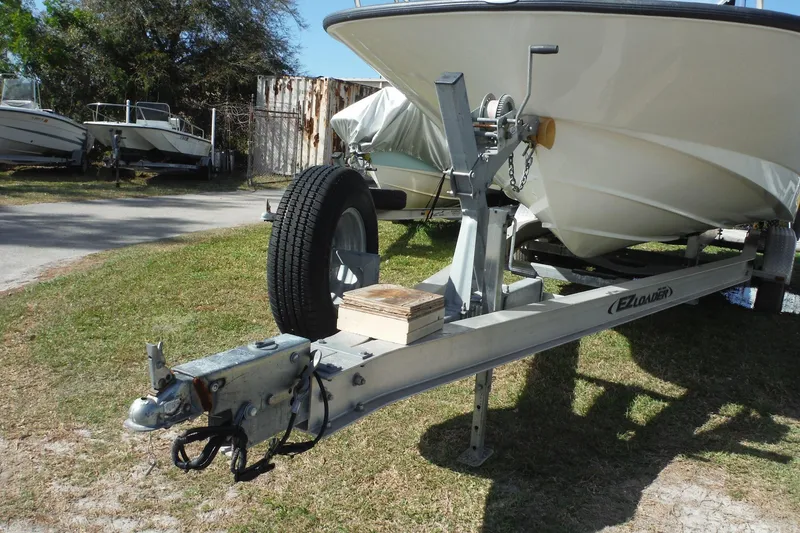 Slide: The Image of 2015 Boston Whaler 210 Montauk on EZ Loader trailer, parked on grass. - 51