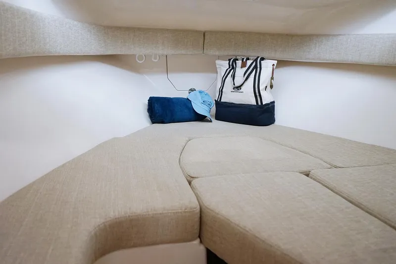 Slide: The Image of Manufacturer Provided Image: 2023 Grady-White Adventure 218 cabin interior with beige cushions and storage bags. - 10