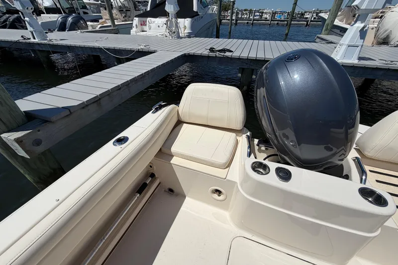 Slide: The Image of 2023 Grady-White Adventure 218 boat at dock, featuring seating and outboard motor. - 15