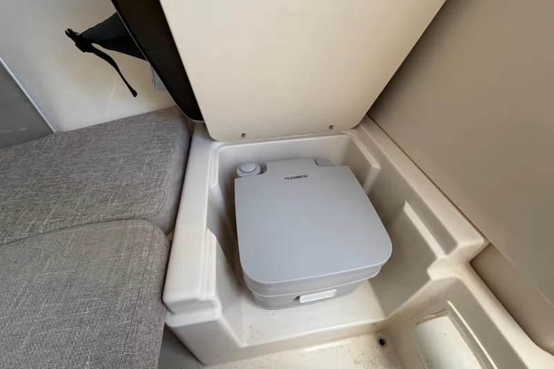 Slide: The Image of 2023 Grady-White Adventure 218 boat interior with Dometic portable toilet. - 17