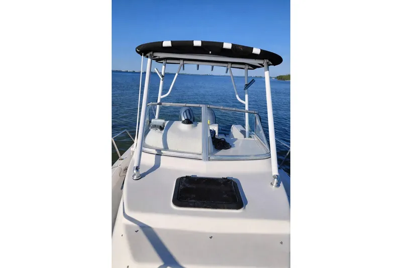 Slide: The Image of 2001 Key West 2300 Bluewater boat on calm water with T-top and clear sky. - 2