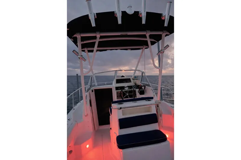 Slide: The Image of 2001 Key West 2300 Bluewater boat interior at sunset, featuring helm and seating. - 5