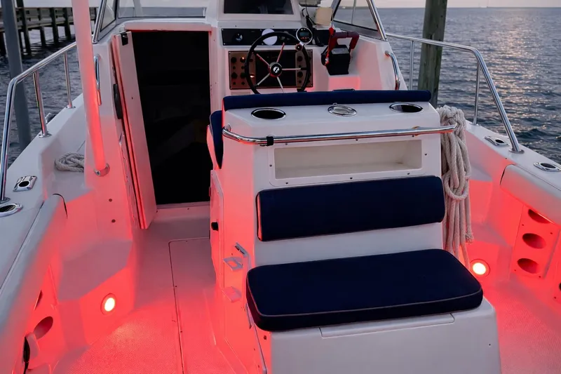 Slide: The Image of 2001 Key West 2300 Bluewater boat interior with red lighting and navy seating. - 6