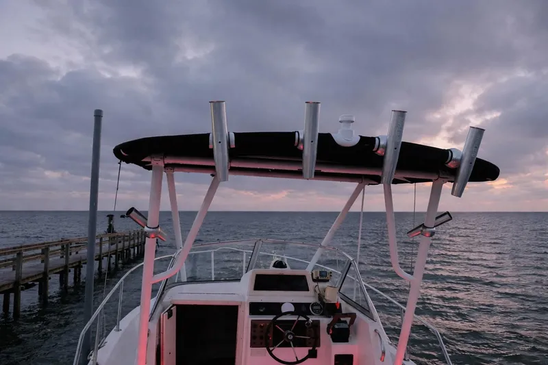 Slide: The Image of 2001 Key West 2300 Bluewater boat at sea during sunset, near a wooden pier. - 7