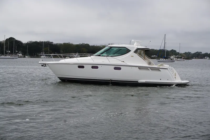Slide: The Image of 2007 Tiara Yachts 3900 Sovran cruising on a calm waterway under cloudy skies. - 22