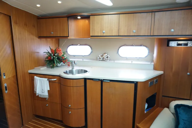Slide: The Image of 2007 Tiara Yachts 3900 Sovran interior with wooden cabinetry and modern kitchenette. - 5