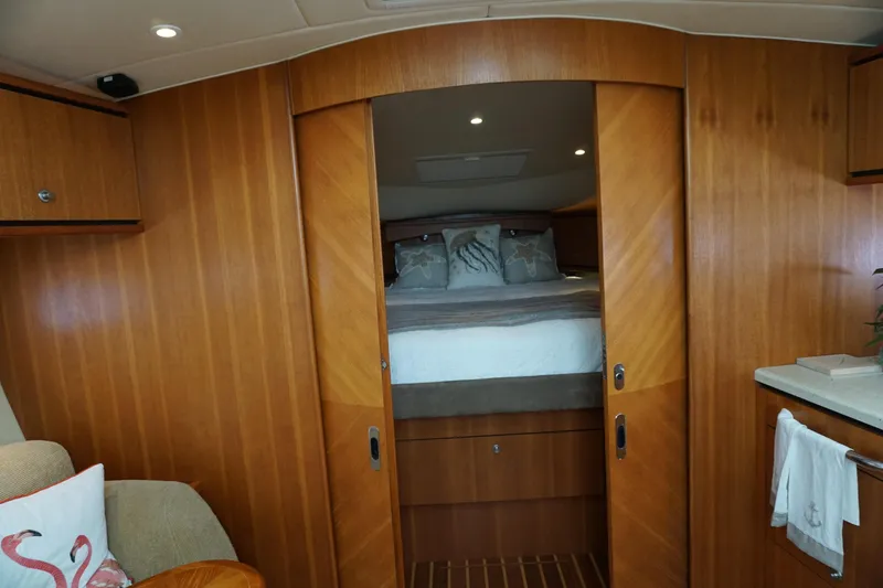 Slide: The Image of Luxurious 2007 Tiara Yachts 3900 Sovran cabin interior with wood paneling and cozy bedding. - 7