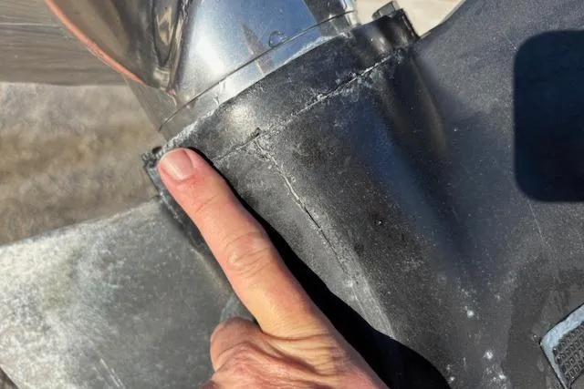 Slide: The Image of Close-up of a person pointing at a crack on a 1984 Mako 221 Center Console boat propeller. - 30