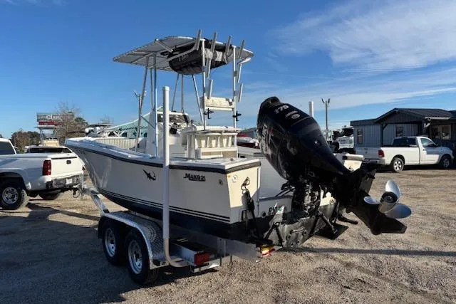 Slide: The Image of 1984 Mako 221 Center Console boat on trailer with outboard motor in parking lot. - 9