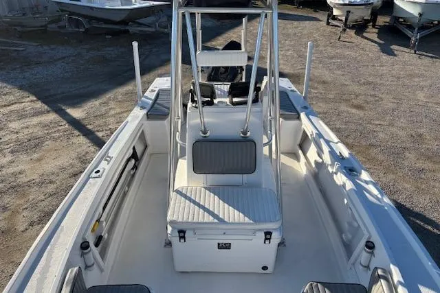 Slide: The Image of 1984 Mako 221 Center Console boat with seating and storage, parked on gravel. - 16