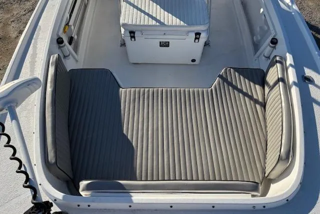Slide: The Image of 1984 Mako 221 Center Console boat interior with cushioned seating and storage. - 17