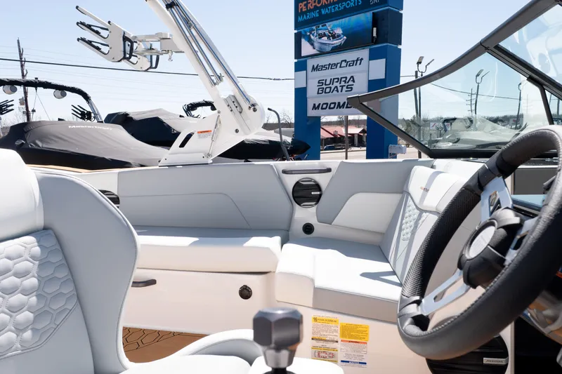 Slide: The Image of 2026 MasterCraft NXT24 boat interior with steering wheel and seating, displayed at a marine dealership. - 17