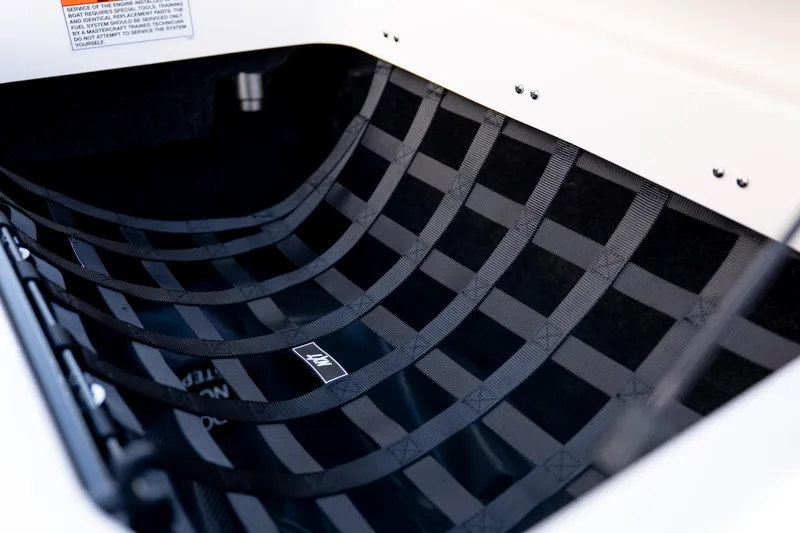 Slide: The Image of 2026 MasterCraft NXT24 boat storage compartment with black netting. - 23