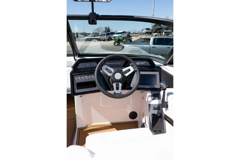 Slide: The Image of 2026 MasterCraft NXT24 boat dashboard with steering wheel and controls. - 27