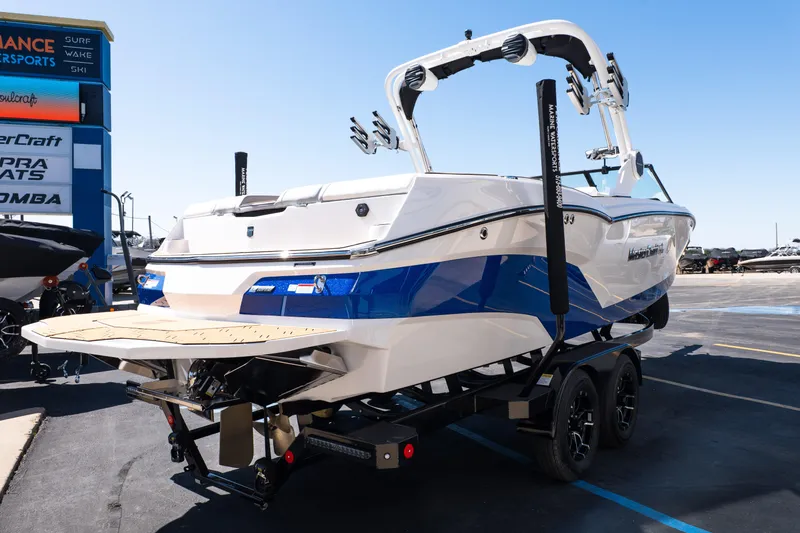 Slide: The Image of 2026 MasterCraft NXT24 boat on trailer, displayed outdoors at a dealership. - 6
