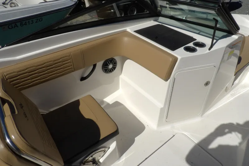 Slide: The Image of 2023 Searay 210 SPO boat interior with tan seating and storage compartment. - 5