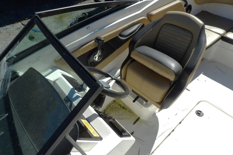 Slide: The Image of 2023 Searay 210 SPO boat interior with steering wheel and seating. - 6