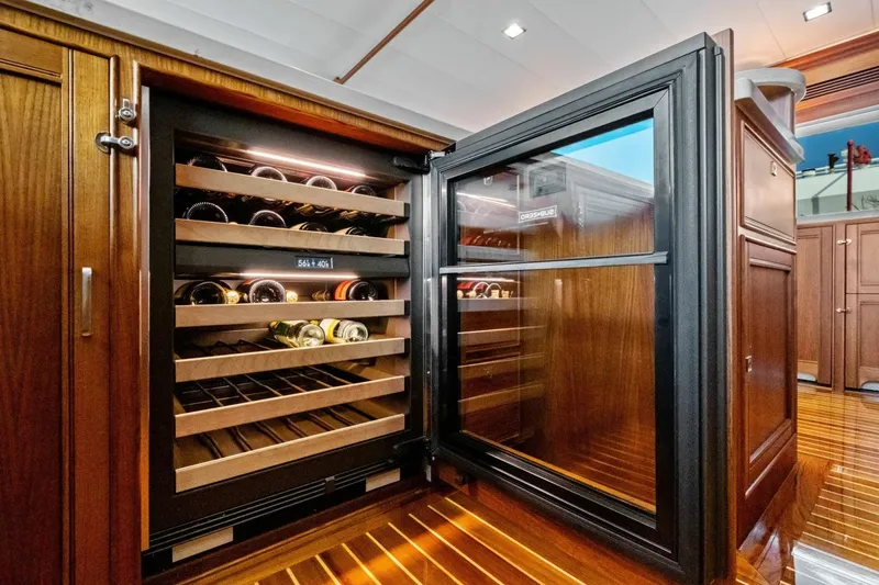 Slide: The Image of Luxurious wine cooler in 2024 Marlow 90 V yacht interior, featuring wooden cabinetry. - 24