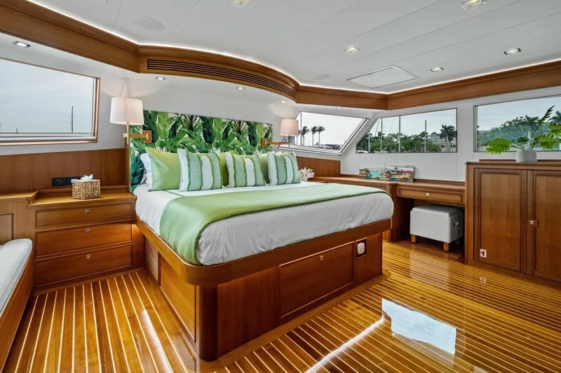 Slide: The Image of Luxurious 2024 Marlow 90 V yacht bedroom with elegant wood finish and green accents. - 25