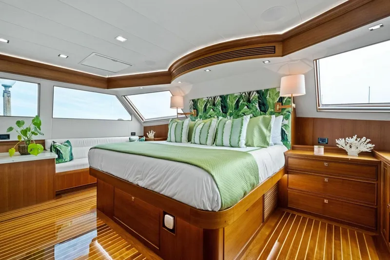 Slide: The Image of Luxurious 2024 Marlow 90 V yacht bedroom with elegant wood finish and green accents. - 26