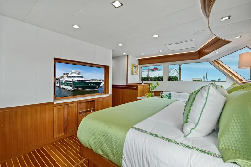 Slide: The Image of Luxurious 2024 Marlow 90 V yacht bedroom with elegant wood finishes and large windows. - 28