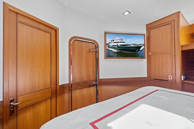 Slide: The Image of Luxurious cabin interior of 2024 Marlow 90 V yacht with wooden finishes and framed yacht photo. - 39
