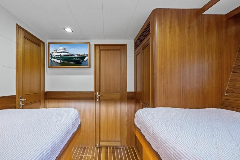 Slide: The Image of Luxurious cabin interior of 2024 Marlow 90 V yacht with wooden finishes and twin beds. - 49