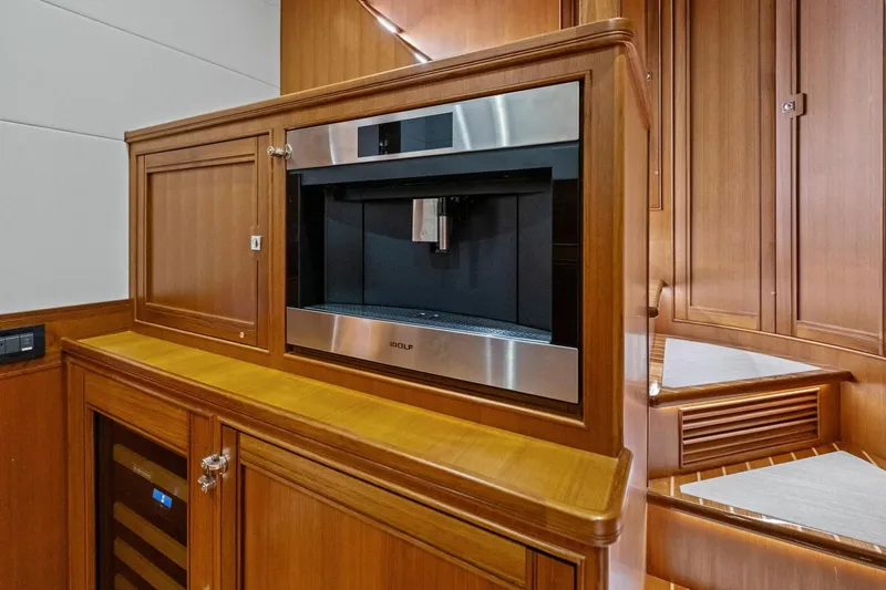 Slide: The Image of Luxury yacht Marlow 90 V 2024 interior with built-in coffee machine and wooden cabinetry. - 52