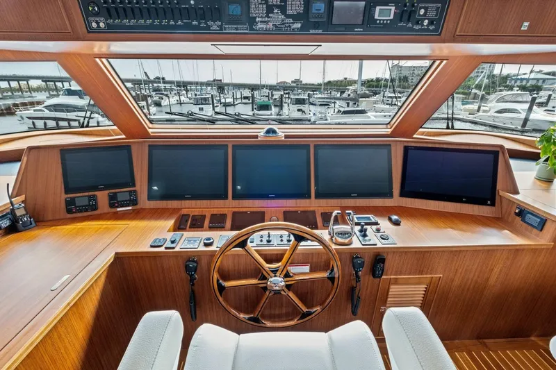 Slide: The Image of Helm of 2024 Marlow 90 V yacht with advanced navigation displays and wooden steering wheel. - 67