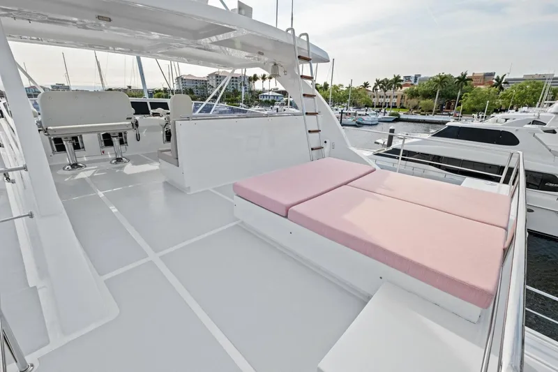 Slide: The Image of Luxurious 2024 Marlow 90 V yacht deck with pink sun loungers and marina view. - 70