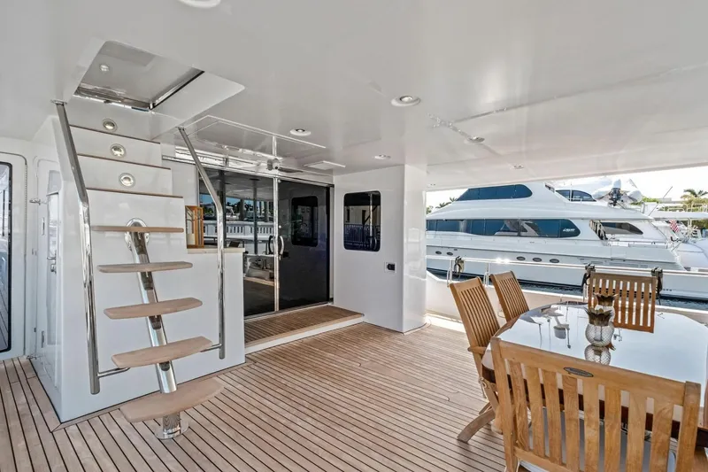 Slide: The Image of Luxurious 2024 Marlow 90 V yacht deck with wooden dining area and modern staircase. - 75