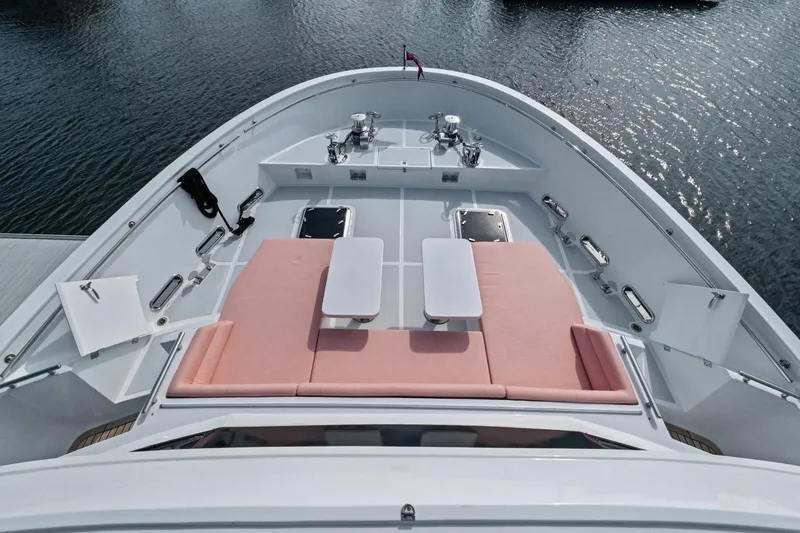 Slide: The Image of 2024 Marlow 90 V yacht deck with pink sun loungers and tables, overlooking water. - 77