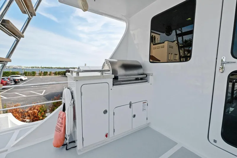 Slide: The Image of Outdoor grill area on 2024 Marlow 90 V yacht, with scenic waterfront view. - 83