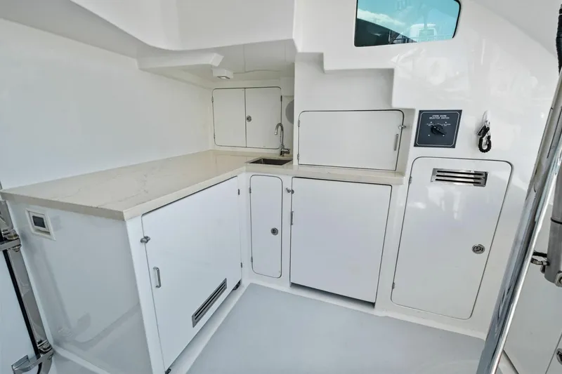 Slide: The Image of Modern galley area in 2024 Marlow 90 V yacht with sleek white cabinetry. - 90